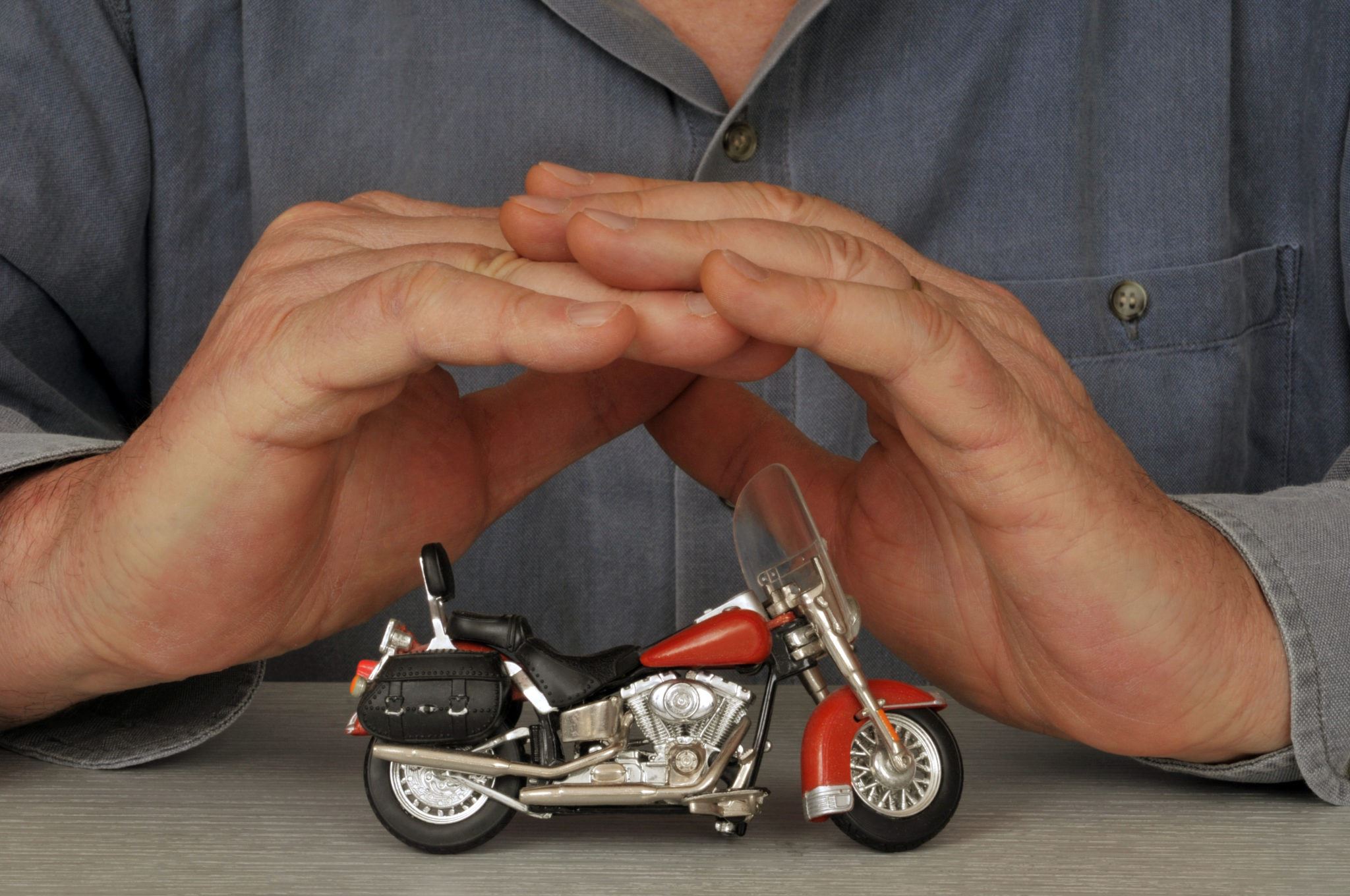 toy motorcycle with mans hands around it